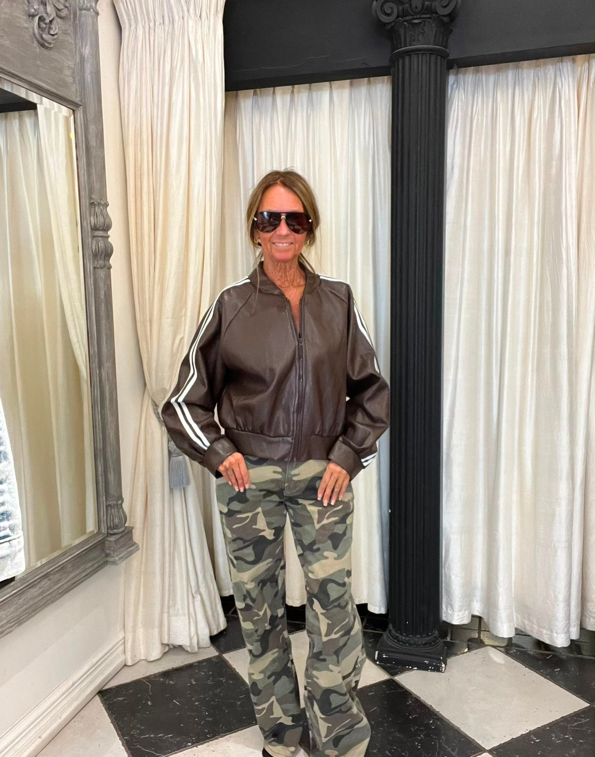 Bruin imitatieleren bomberjack met witte strepen op de mouwen, gecombineerd met army jeans